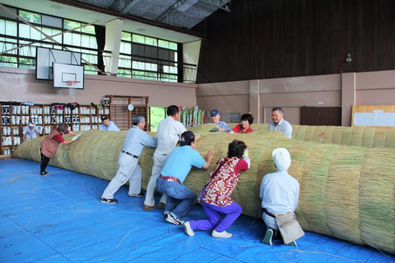 中の稲穂をコモで覆う作業も一苦労